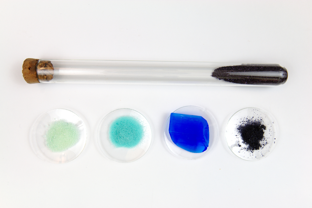 nico europe info chemie türkise, grüne, schwarze salze, blaue mineralien in petrischalen, daneben verkorktes reagenzgläschen mit schießpulver